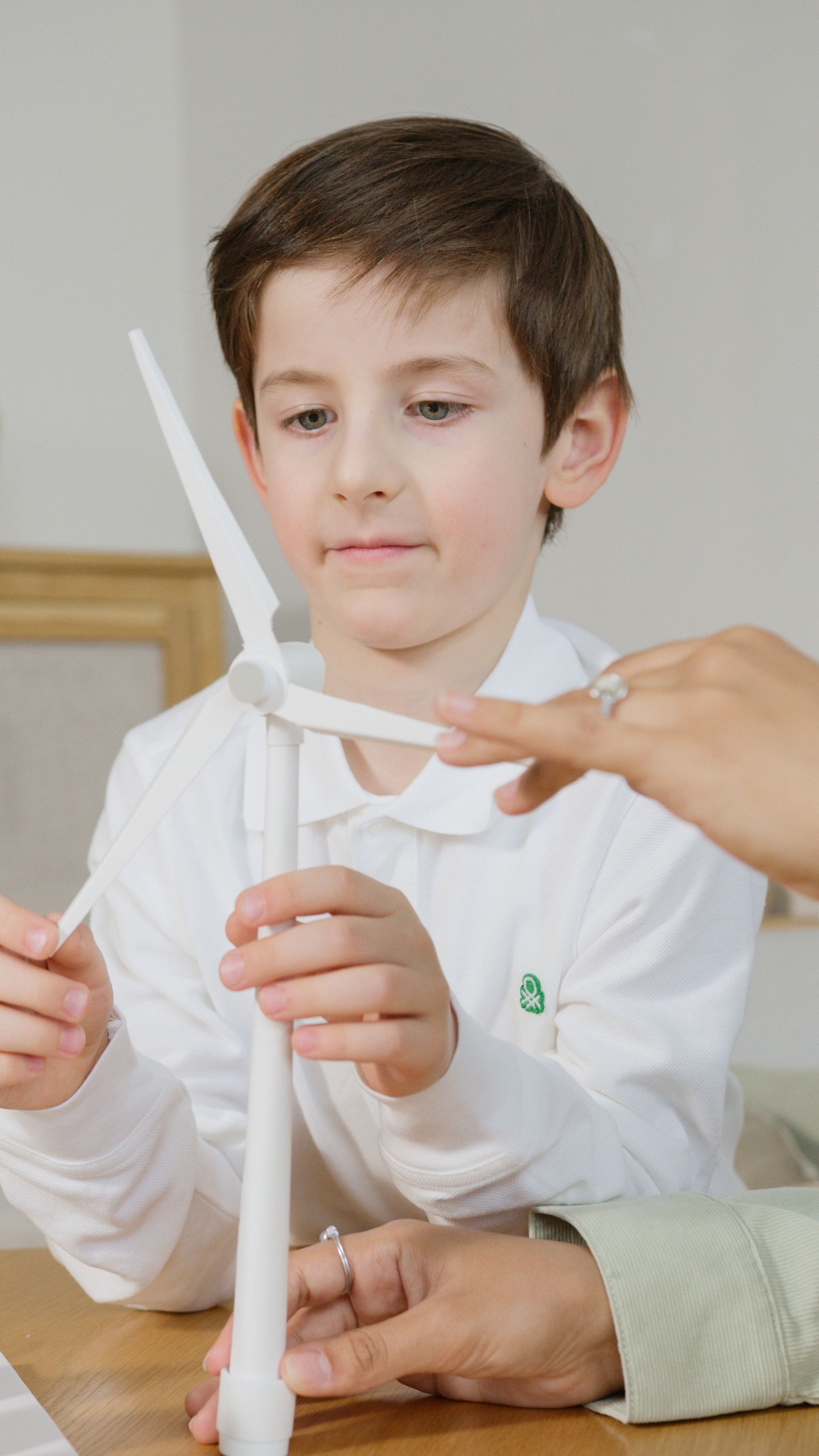 Boy experimenting with a propeller turbine in class as part of a school STEM enrichment programme